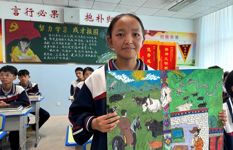 果洛西寧民族中學(xué)學(xué)生尼東拉毛在主題思政課上展示表現(xiàn)現(xiàn)代化家鄉(xiāng)的作品。