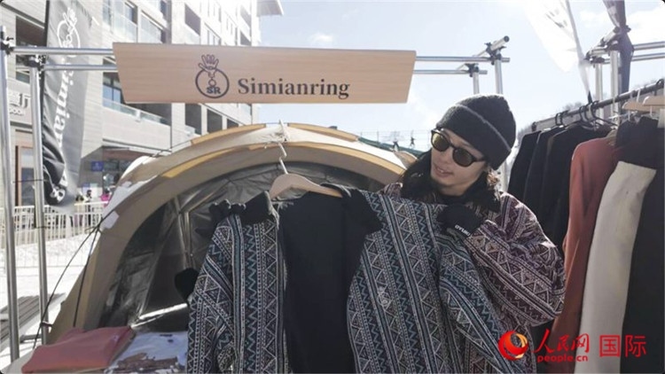 藤田周正在展示自己設(shè)計(jì)的滑雪服。人民網(wǎng)記者 袁蒙攝
