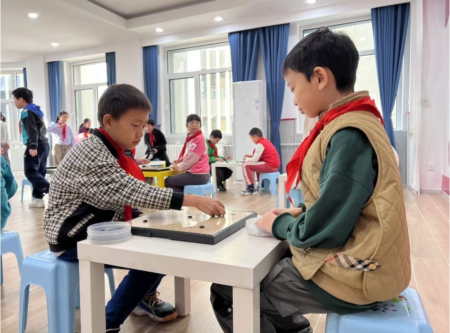 學(xué)生們?cè)谏傧汝?duì)大廳下圍棋。人民網(wǎng) 白炅攝