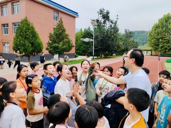 孩子們在操場和老師一起試飛無人機(jī)（沈怡辰 攝）