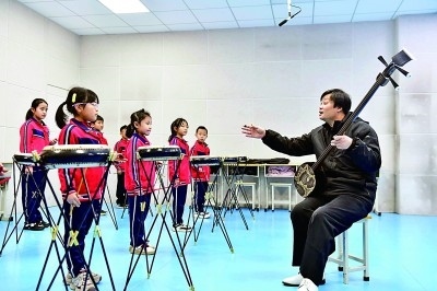 圖為12月30日，在惠民縣胡集鎮(zhèn)第一小學(xué)，老師指導(dǎo)學(xué)生學(xué)習(xí)西河大鼓。新華社記者 郭緒雷攝