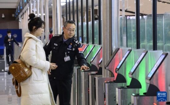 1月2日，大興機(jī)場(chǎng)邊檢站警察指導(dǎo)旅客使用自助出境設(shè)備。新華社記者 李欣 攝