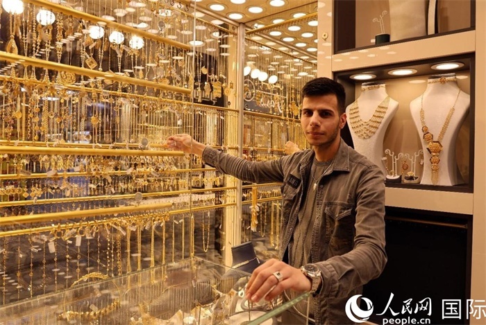一名銷售員展示黃金飾品。人民網(wǎng) 伊納斯·易卜拉欣攝