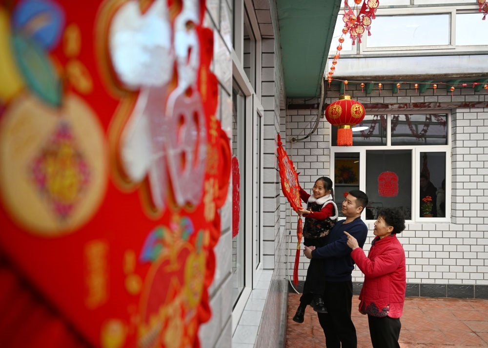 天津市西青區(qū)辛口鎮(zhèn)第六埠村村民在院子里掛“福”字（2024年2月1日攝）。新華社記者 趙子碩 攝