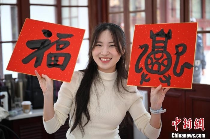 1月20日，馬來(lái)西亞留學(xué)生展示其創(chuàng)作的福貼。當(dāng)日，來(lái)自巴西、馬來(lái)西亞、加納、哈薩克斯坦的外籍留學(xué)生在浙江杭州西泠印社體驗(yàn)福貼、春聯(lián)和篆刻，感受古老的中國(guó)傳統(tǒng)文化。中新社記者 王剛 攝