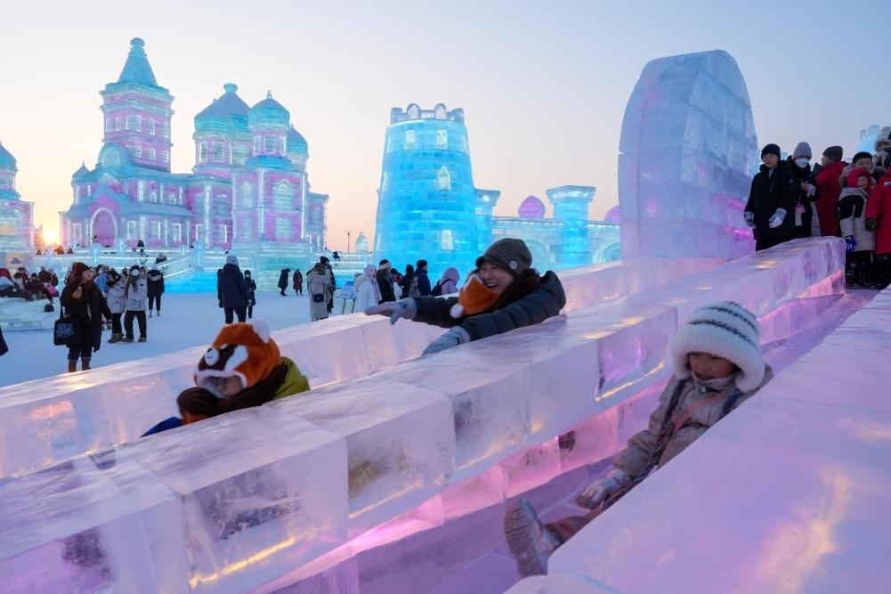游客在哈爾濱冰雪大世界園區(qū)內(nèi)體驗(yàn)冰滑梯。新華社發(fā)