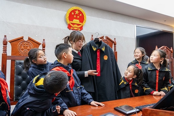圖②：干警向同學(xué)們介紹法袍。