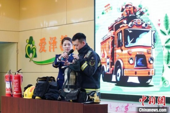 圖為消防員介紹消防裝備。中新社記者 趙宇航 攝