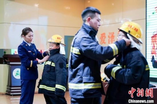圖為學(xué)生們現(xiàn)場(chǎng)穿戴消防頭盔和戰(zhàn)斗服。中新社記者 趙宇航 攝