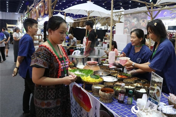 游客在攤位前購(gòu)買(mǎi)特色美食。朱瀟逸攝