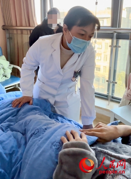 鄧茜查房時(shí)詢問患者情況。人民網(wǎng)記者 金慧慧攝