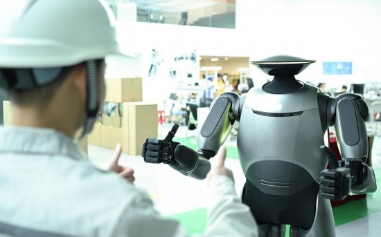 在廣汽研究院，人形機器人團隊的周仁義在演示GoMate機器人互動功能（新華社記者 鄧華 攝）