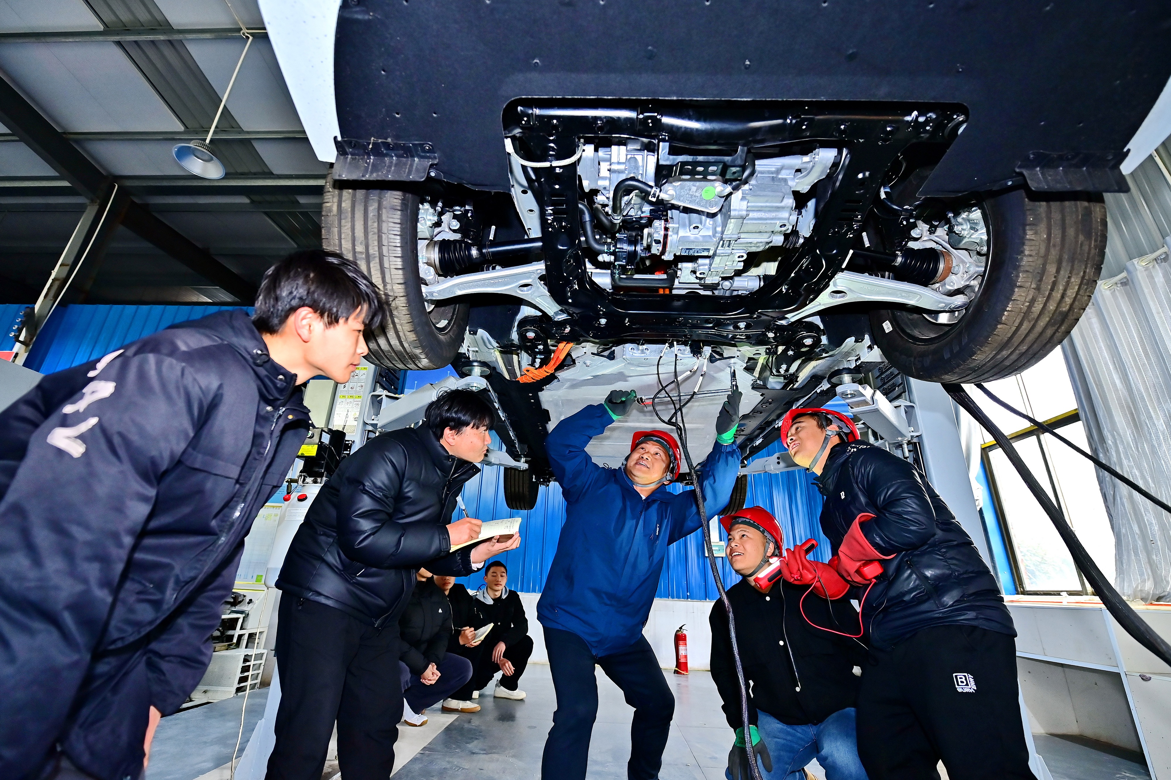 2025年2月，江西省宜春市，豐城市的一所技工學(xué)校實(shí)訓(xùn)基地內(nèi)，新能源汽車運(yùn)維專業(yè)學(xué)生在老師的指導(dǎo)下學(xué)習(xí)新能源汽車電池包檢修技術(shù)。