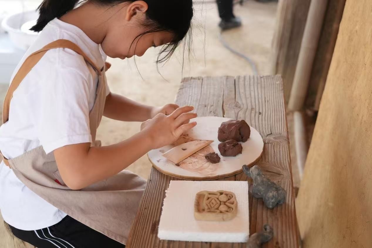 游客制作良渚特色陶藝品。良渚博物院供圖