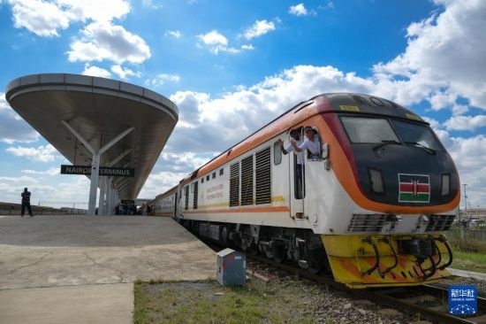 5月31日，在蒙內(nèi)鐵路內(nèi)羅畢站，機車駕駛員蔣立平（右）和博爾在即將開往蒙巴薩的E2次列車上揮手致意。新華社記者 楊光 攝